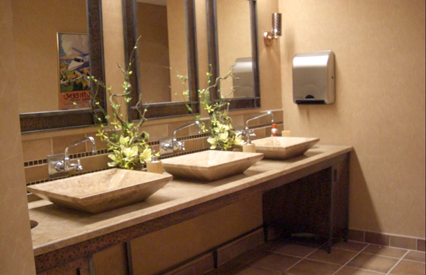 With the use of rustic iron and honed limestone vessel sinks, the bathrooms became an art form and elevated the restrooms from the standard commercial forms to a peaceful respite.